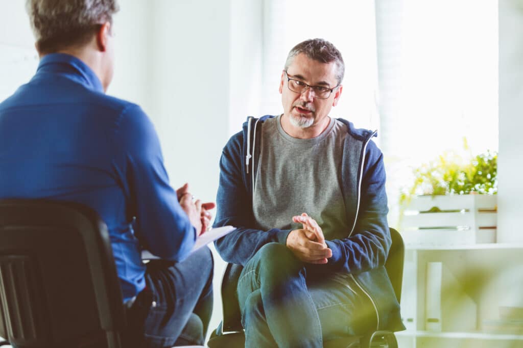 man in gesprek met psychotherapeut in zijn kantoor